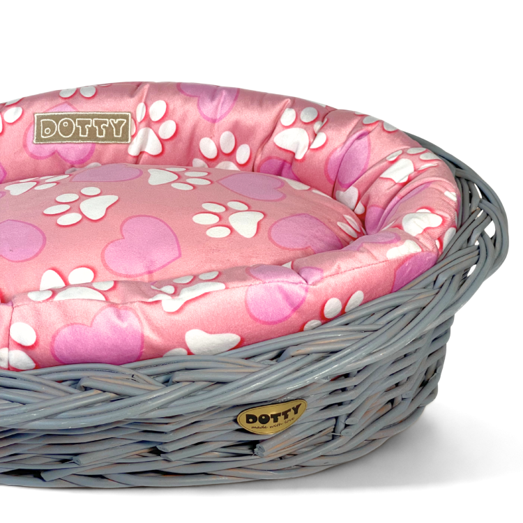 Różowe legowisko ze wzorem serduszek i łapek w koszu z wikliny