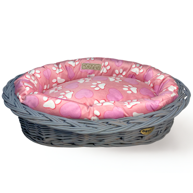 Różowe legowisko ze wzorem serduszek i łapek w koszu z wikliny