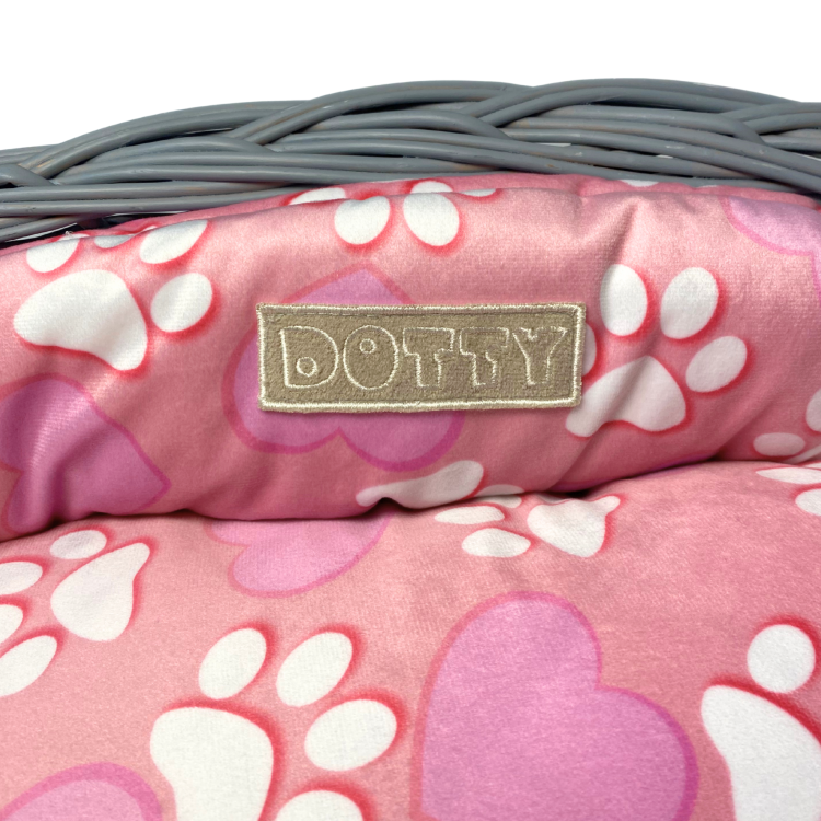 Różowe legowisko ze wzorem serduszek i łapek w koszu z wikliny