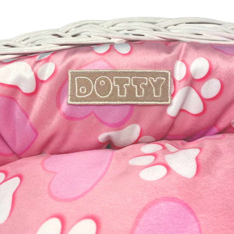 Różowe legowisko ze wzorem serduszek i łapek w koszu z wikliny