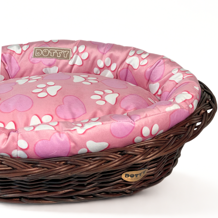 Różowe legowisko ze wzorem serduszek i łapek w koszu z wikliny