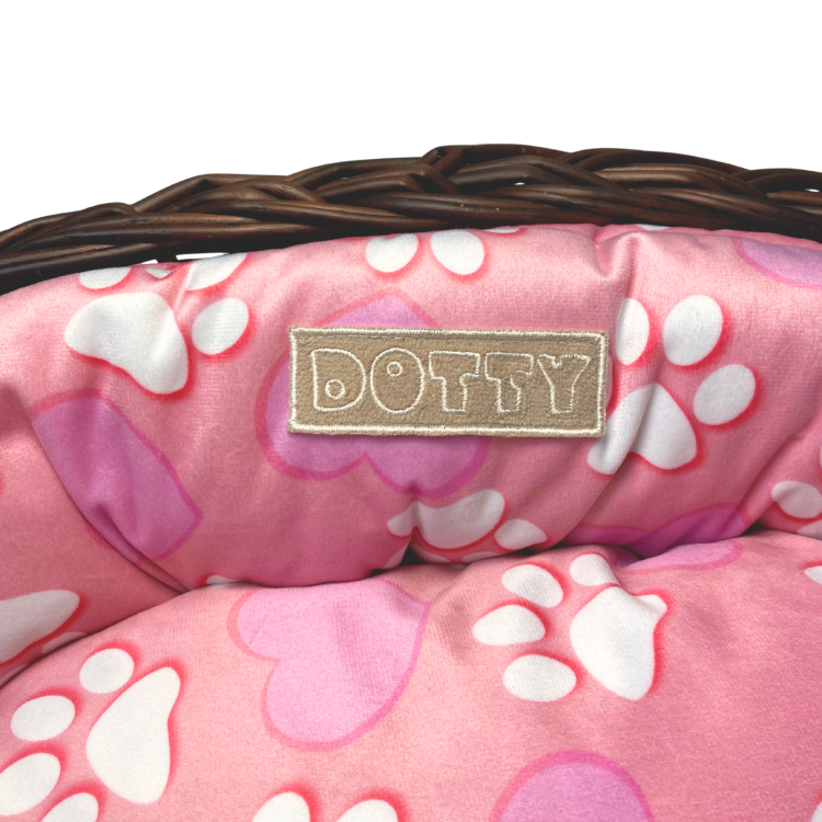 Różowe legowisko ze wzorem serduszek i łapek w koszu z wikliny